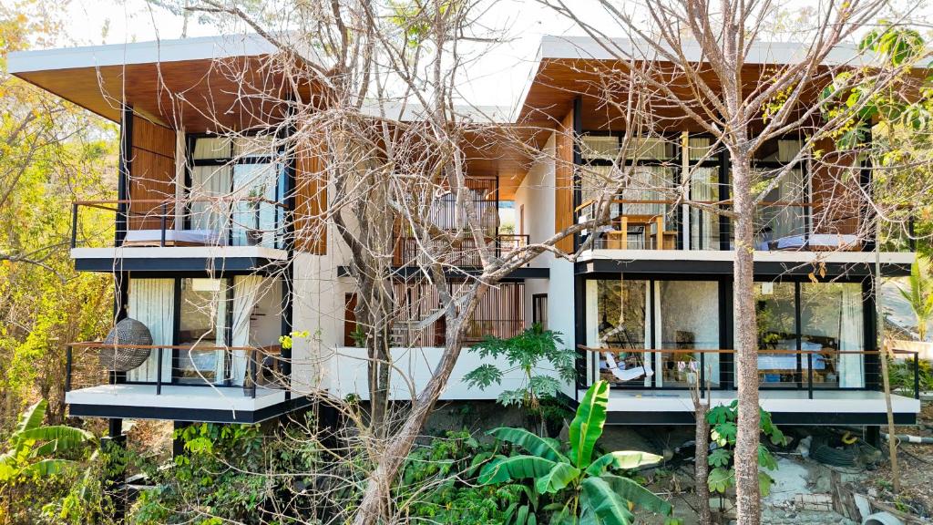 a house with balconies and trees in front of it at Villa Gaspar Terrazas in Playa hermosa