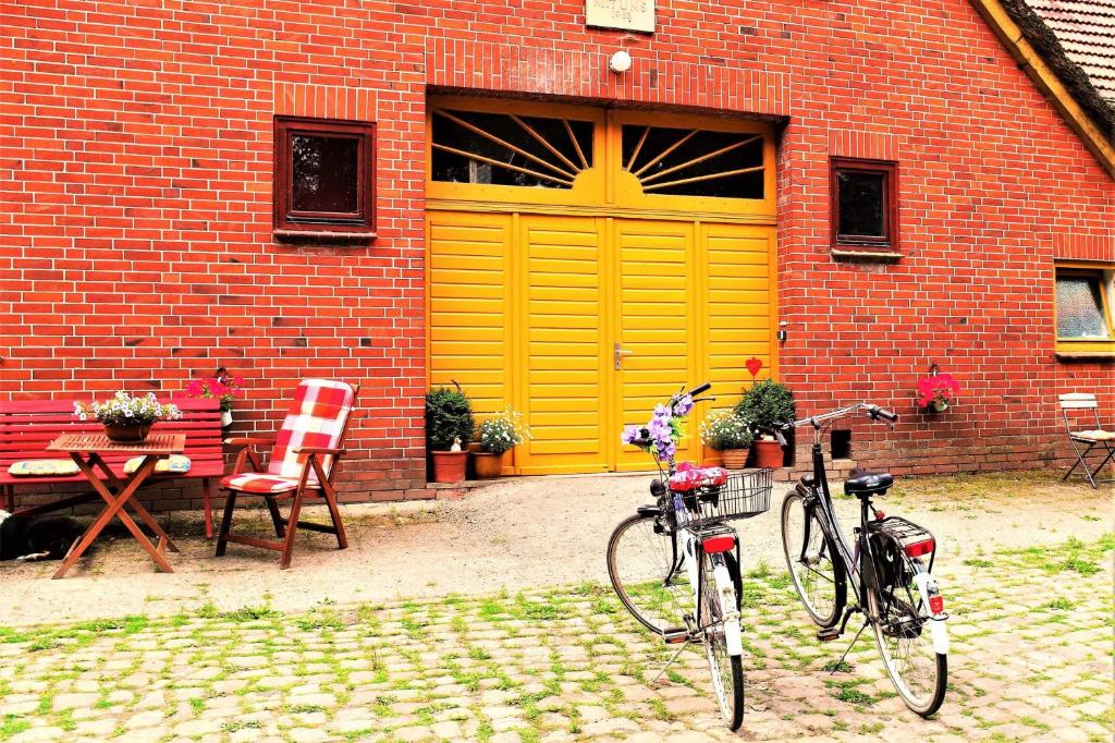 two bikes parked in front of a building with a yellow garage at Schäfchenwolke Apartment auf dem Bauernhof in Worpswede