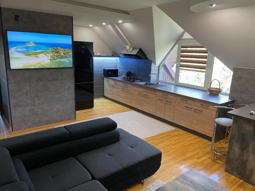 a living room with a couch and a kitchen at Green Garden Apartments in Kaunas