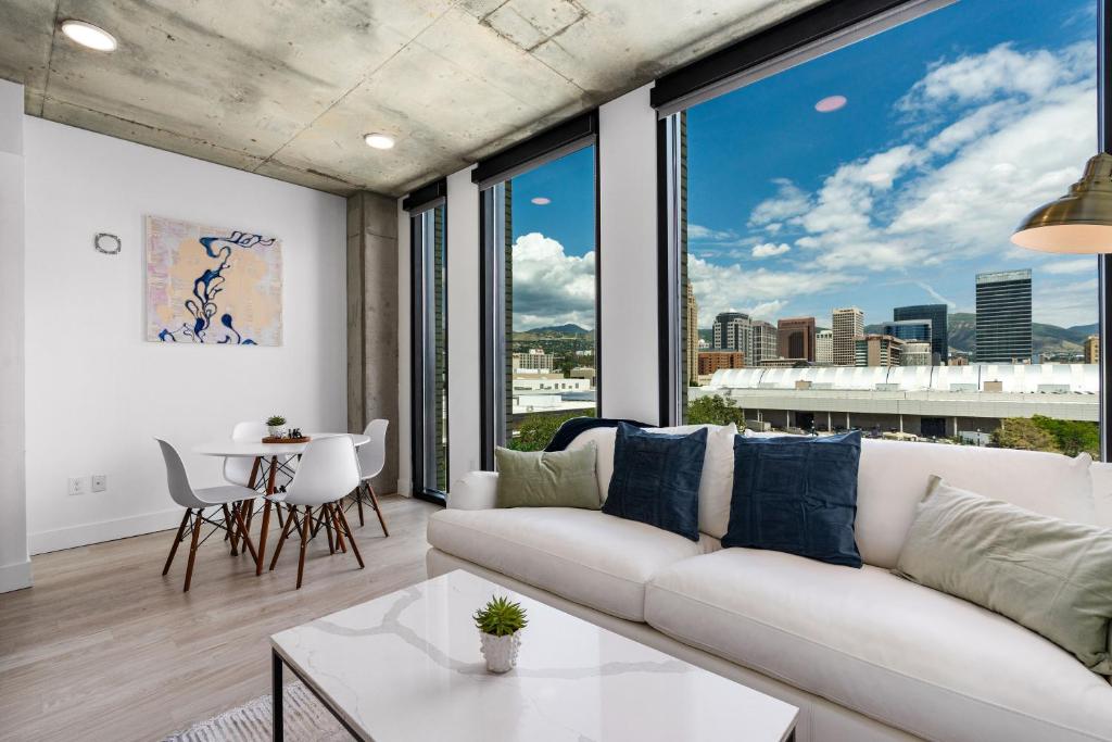a living room with a white couch and large windows at Gorgeous Downtown 1BD 1BA - BEST views & Amenities in Salt Lake City