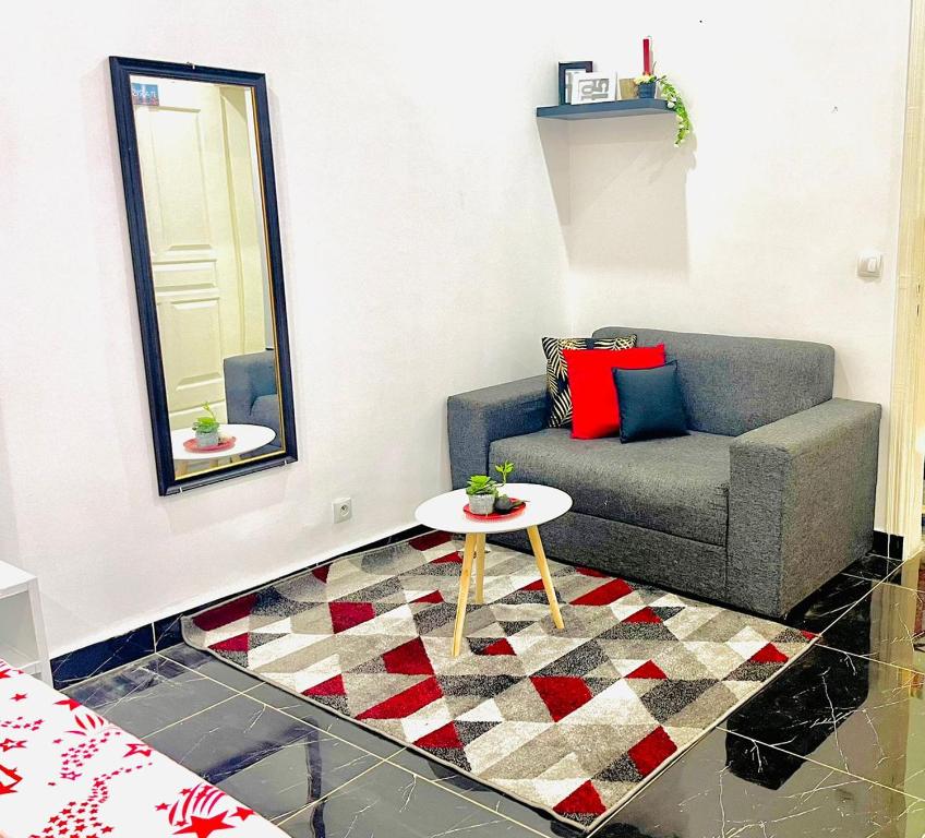 a living room with a couch and a table at Studio Le Parisien in Pointe-Noire