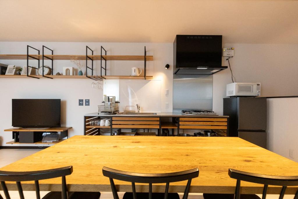 a kitchen with a large wooden table and chairs at Comfort Villa OKINAWA in Yabu