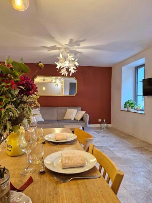 une salle à manger avec une table et un canapé dans l'établissement Belle de Nuit, à Saint-Satur