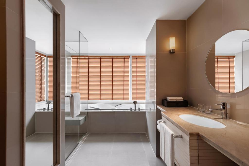 A bathroom with a freestanding-style soaking tub, glass shower and wide vanity.