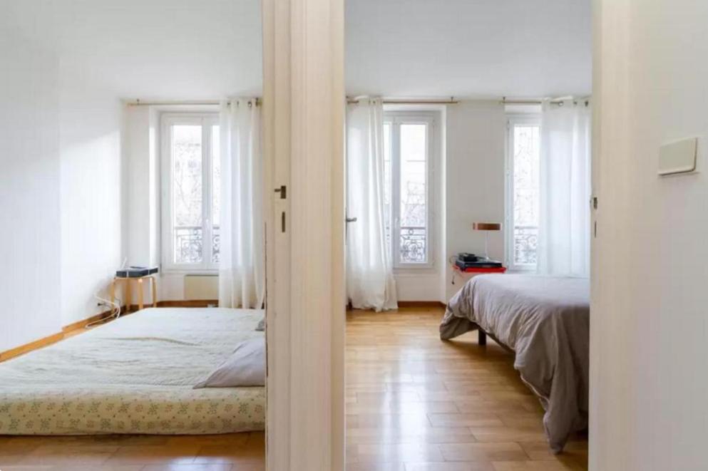 - une chambre blanche avec un lit et des fenêtres dans l'établissement Appartement Paris Centre Vavin2, à Paris