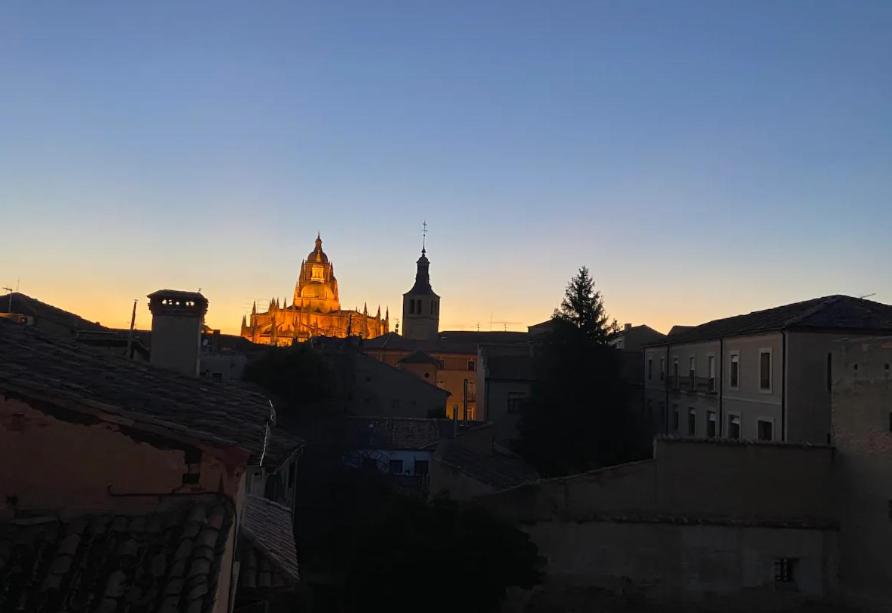 a city skyline at sunset with a building in the background at Sego Apartments III in Segovia