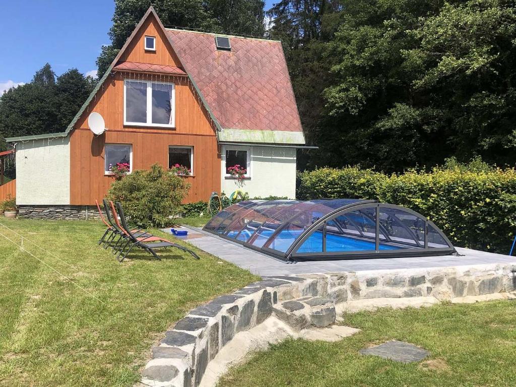 a house with a greenhouse in front of it at Chata pod lesem in Rýmařov