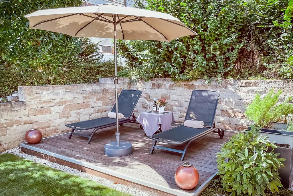 a patio with two chairs and a table with an umbrella at Fewo Bodenseeoase in Wangen