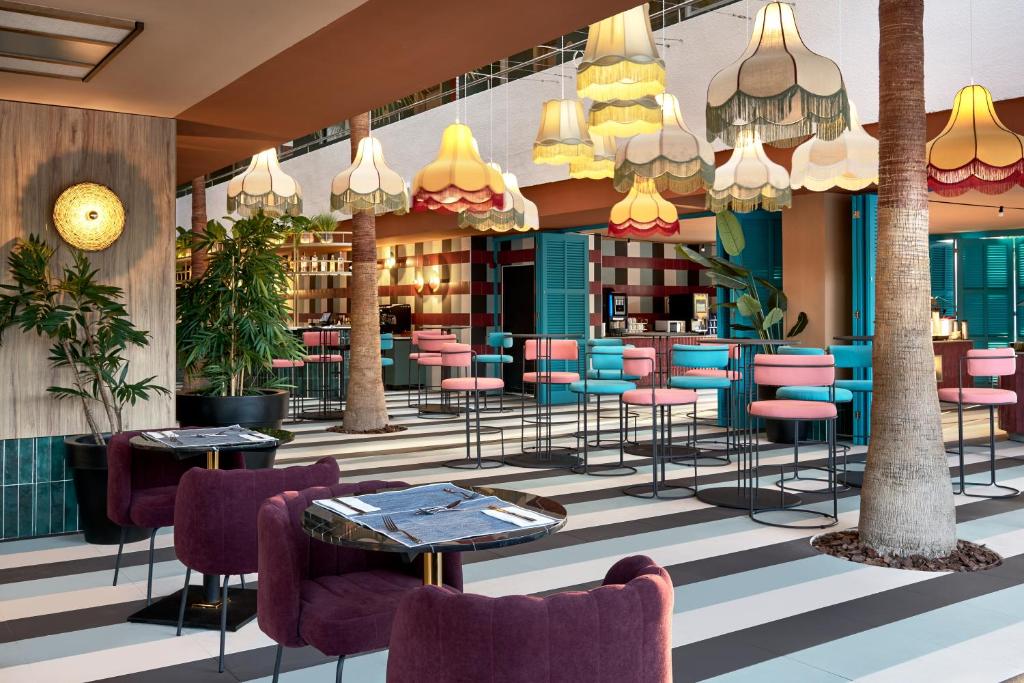 una hall con tavoli e sedie in un edificio di tent Mojito Suites a Magaluf