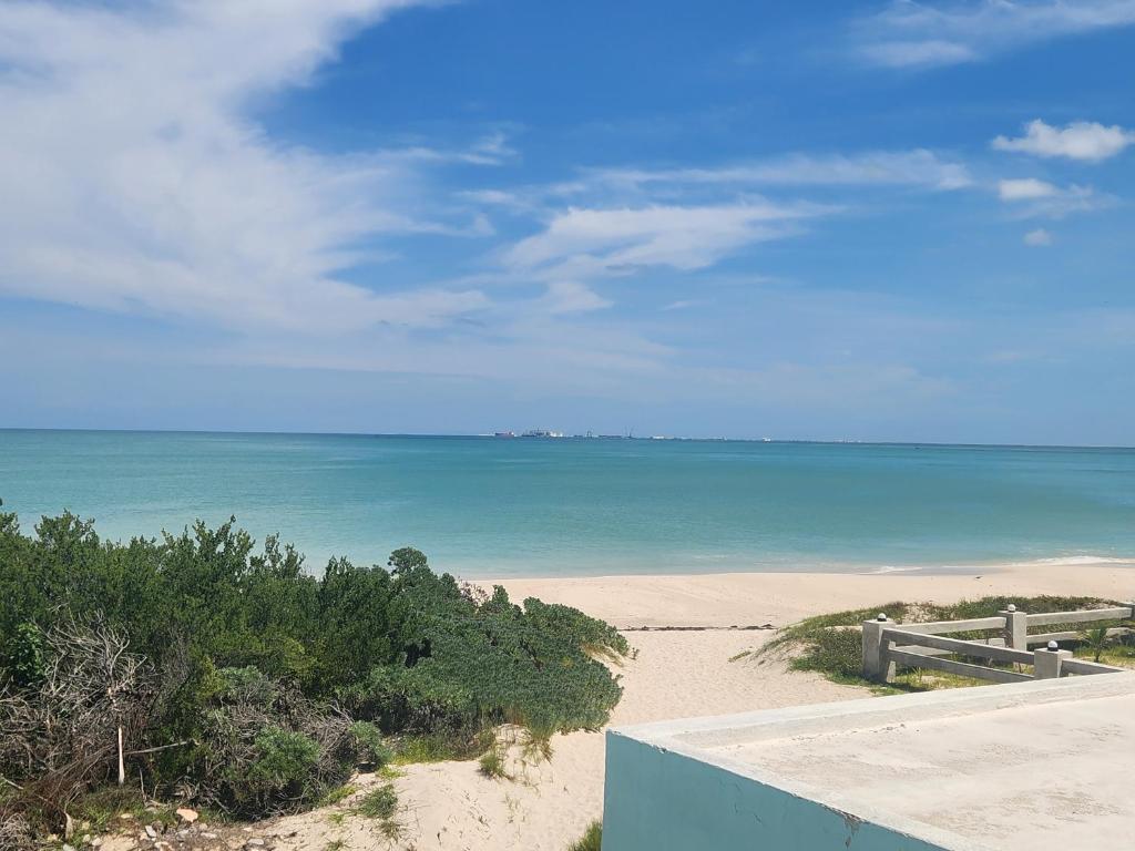 a view of a beach with the ocean in the background at Beautilful ocean views from this apartment in Chelem
