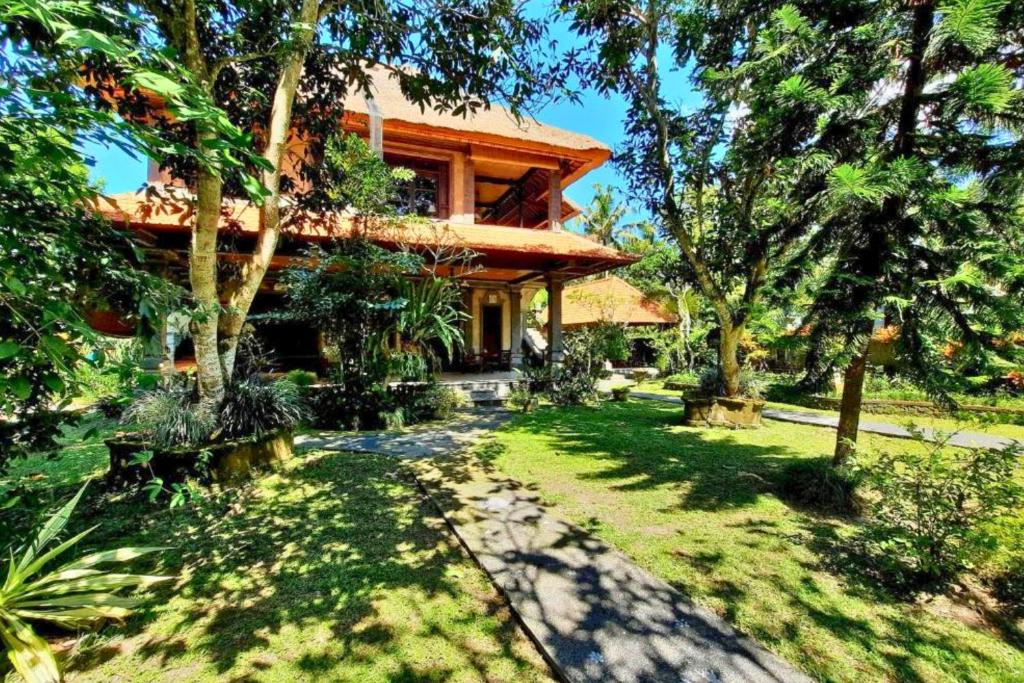 une maison avec une passerelle devant une cour dans l'établissement Falguni 1 BR Grand Deluxe Garden View ZN241, à Ubud