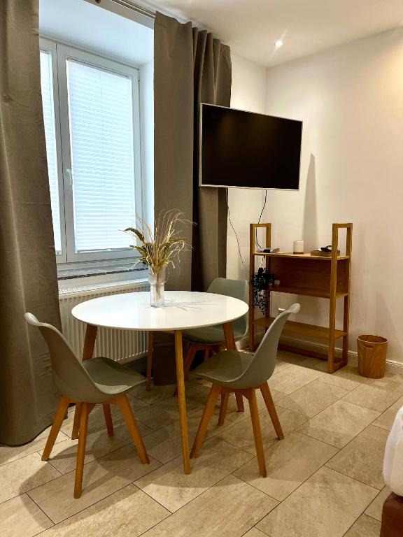 ein Wohnzimmer mit Tisch und Stühlen und einem Fernseher in der Unterkunft Ferienwohnung Dublin in Hannover