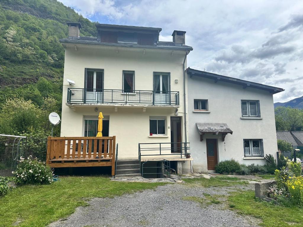 Cette grande maison blanche dispose d'une terrasse couverte et d'un balcon. dans l'établissement Appartement rez de jardin calme proche centre ville, à Luchon
