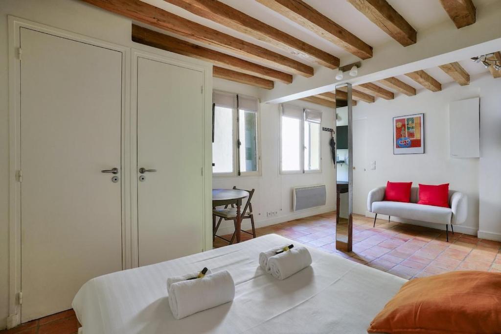 une chambre avec un grand lit blanc avec des oreillers rouges dans l'établissement 3min Notre Dame de Paris | Studio, à Paris