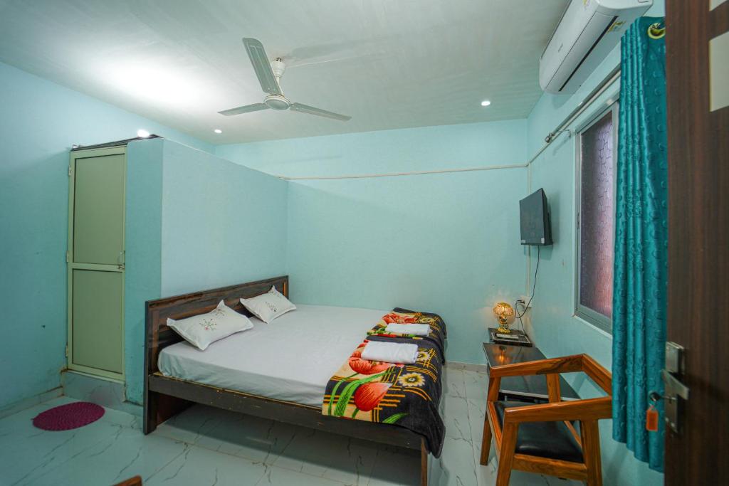a bedroom with a bed with a blue wall at Hotel Ramlalla Palace in Ayodhya