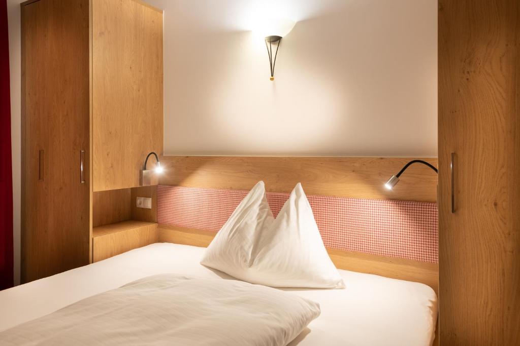 Postel nebo postele na pokoji v ubytování Hotel Gasthof Kröll - inkl Nationalpark-Karte, 1 x Grossglockner Hochalpenstraße kostenlos, verschiedene Bergbahnen kostenlos, Badesee kostenlos, Bus & Zug kostenlos, regionale Küche
