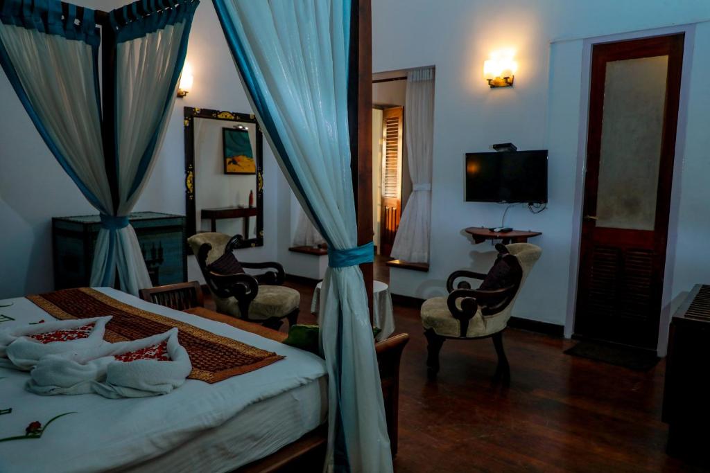 Postel nebo postele na pokoji v ubytování Old Lighthouse Bristow Hotel , Fort Kochi