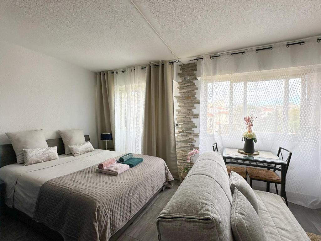 une chambre avec deux lits et un canapé dans l'établissement Cet été à Cannes, Studio cosy à 8' de la Croisette, à Cannes