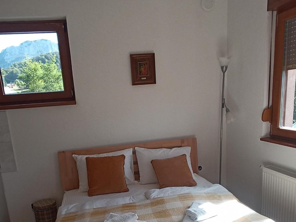 a bed in a room with a window and a bed sidx sidx sidx at Apartmani Jelenača prizemlje in Trnovo