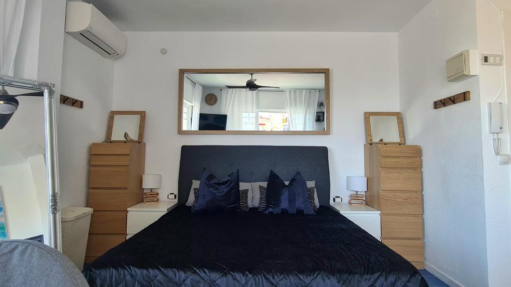 a bedroom with a black bed with a mirror at Estudio Mediterráneo in Nerja