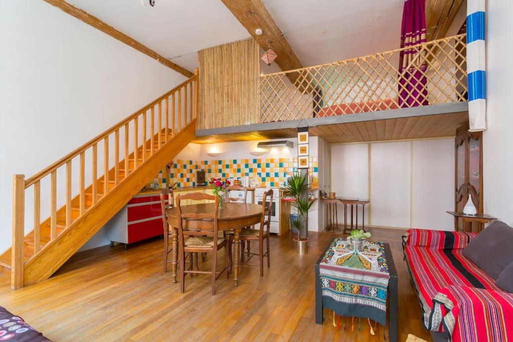 un salon avec une table et un escalier dans l'établissement beau canut à côté du gros cailloux, à Lyon