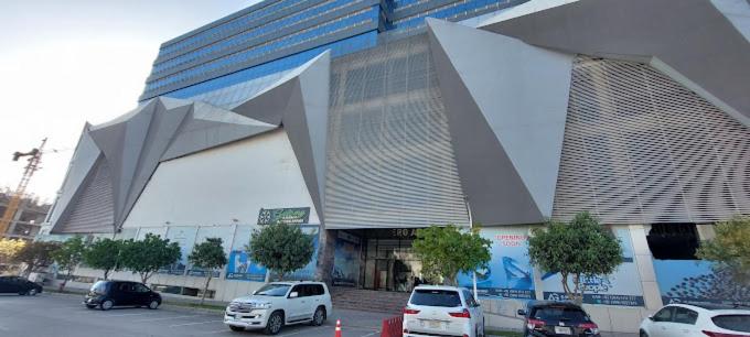 a large building with cars parked in a parking lot at One bed furnished appartment in Darwāla
