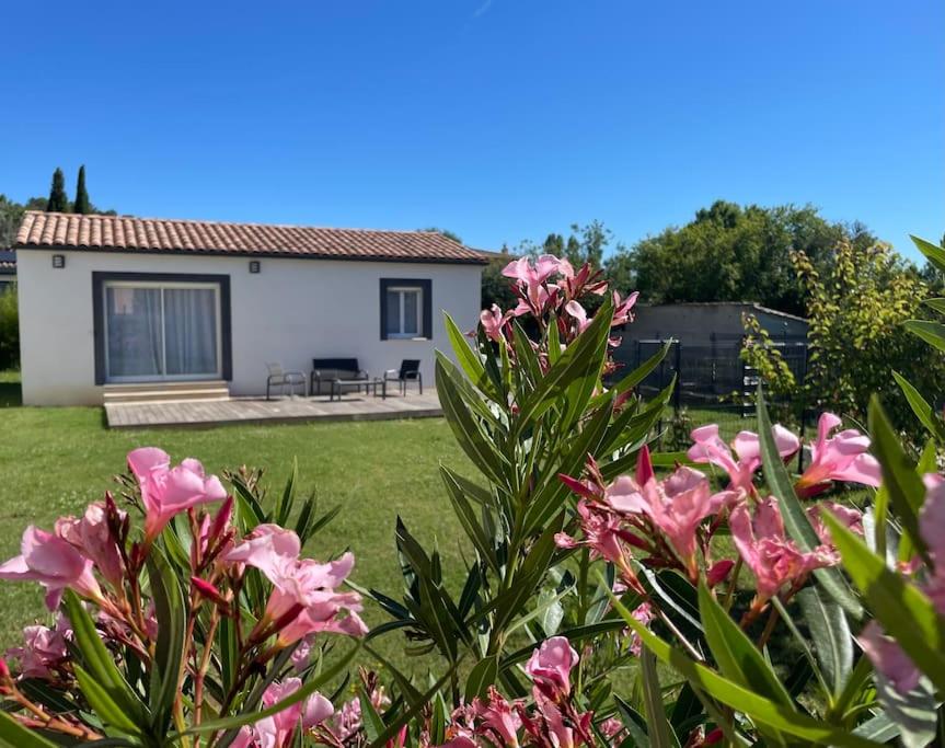 une maison avec des fleurs roses dans la cour dans l'établissement Maison Les Lauriers, à Le Val