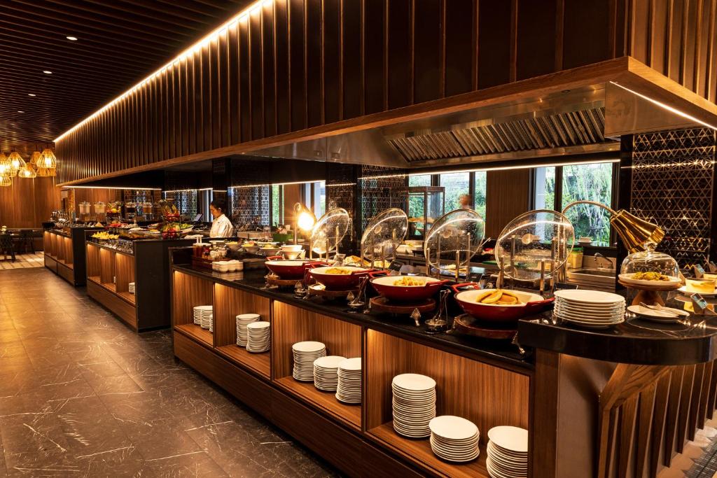 A long self-service breakfast buffet with hot dishes, plates and serving equipment.