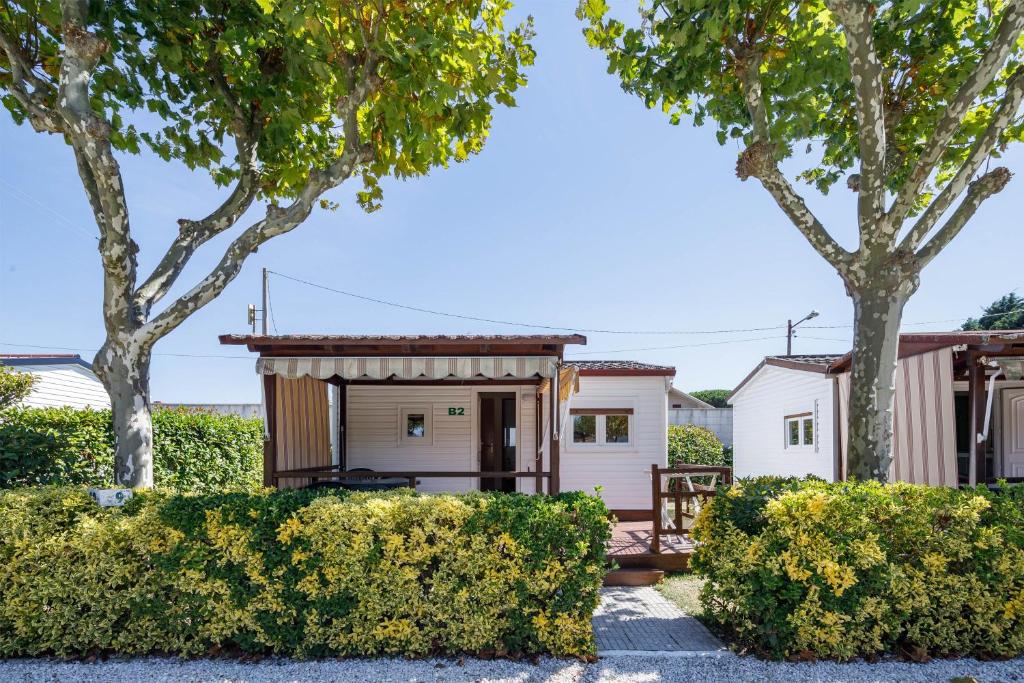una casa pequeña con porche y árboles en Bungalow B1, en Pontevedra