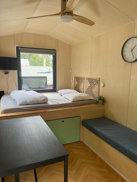 Cette chambre comprend deux lits et une horloge murale. dans l'établissement Tiny house, à Saint-Usage