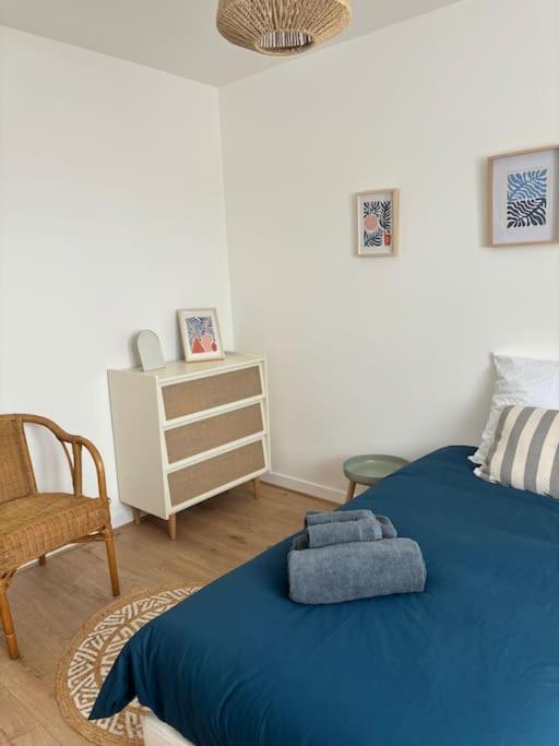 - une chambre avec un lit bleu et une chaise dans l'établissement Maison entière 4 chambres, à Le Blanc