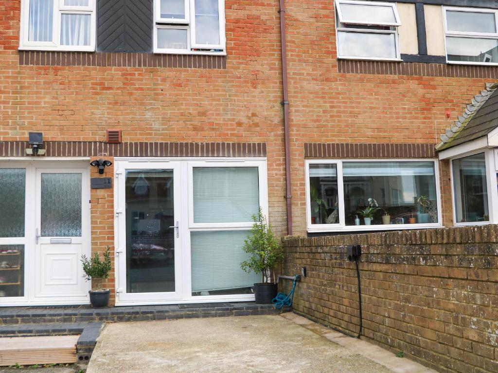 a brick house with white doors and windows at Beach Retreat in Seaford