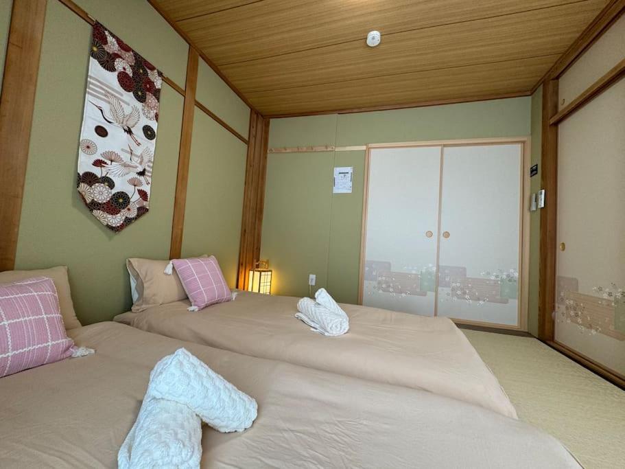 Postel nebo postele na pokoji v ubytování 木香の家-天下茶屋