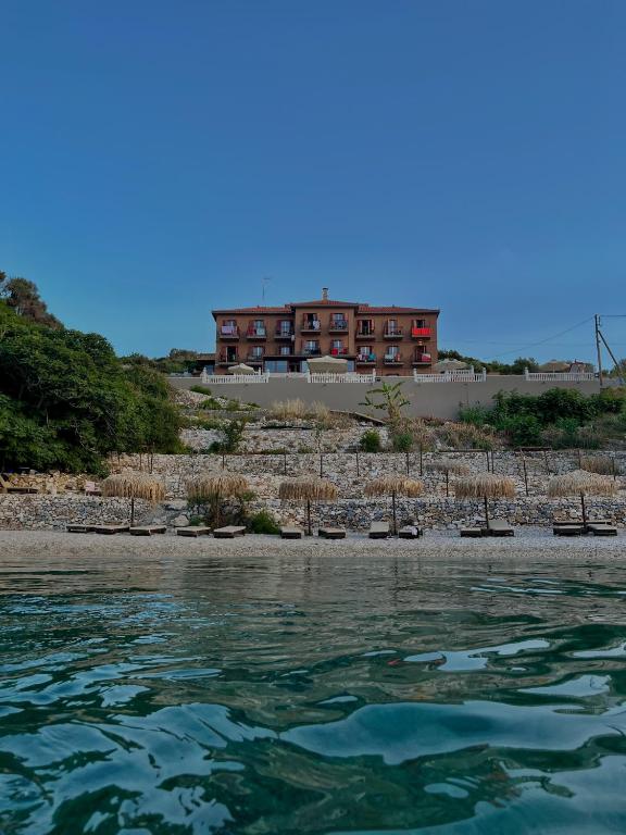 a building on a hill next to a body of water at Sunrise in Kokkari