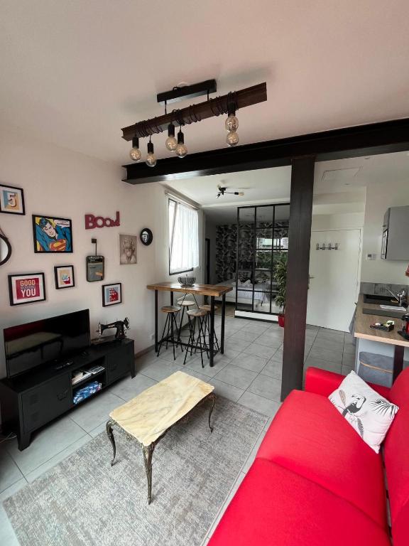 un salon avec un canapé rouge et une table dans l'établissement Appartement hôtel de ville INDUS, à Vannes