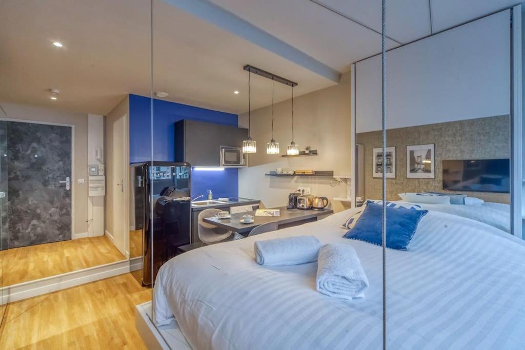 - une grande chambre avec un grand lit blanc et des oreillers bleus dans l'établissement R'Apparts Studio Luxury N 9, à Grenoble