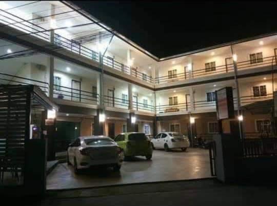 a building with two cars parked in a parking lot at Pichayapa Place in Ban Pa Sang (1)