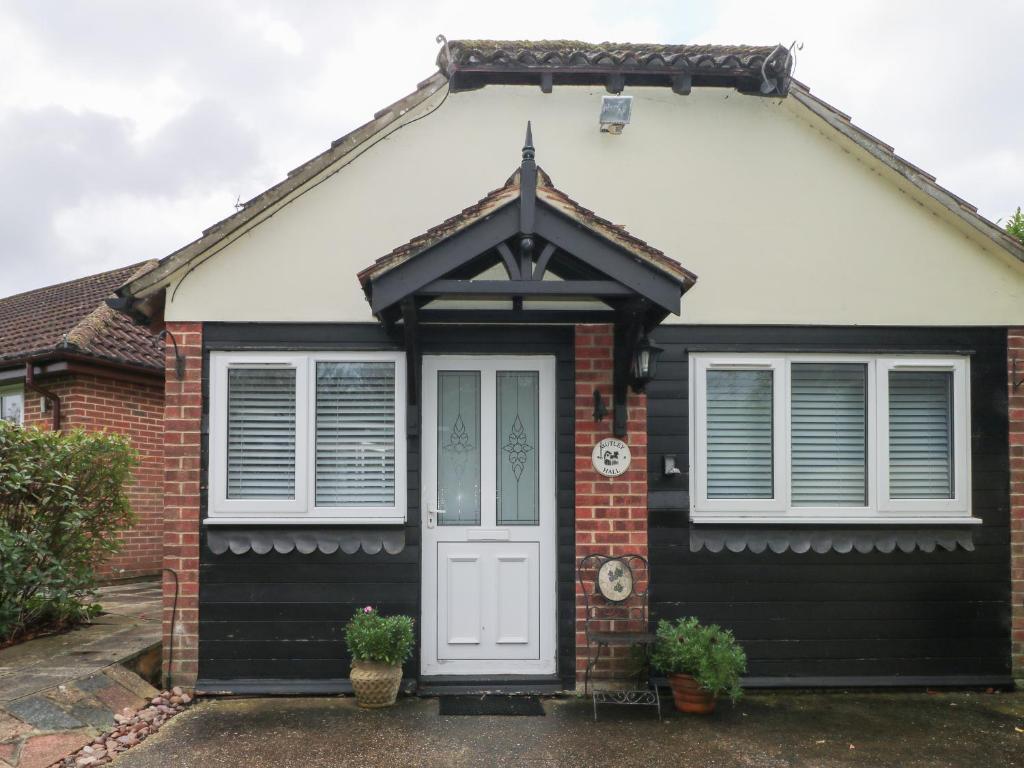 a black and white house with a white door at Mutley Hall in Chichester