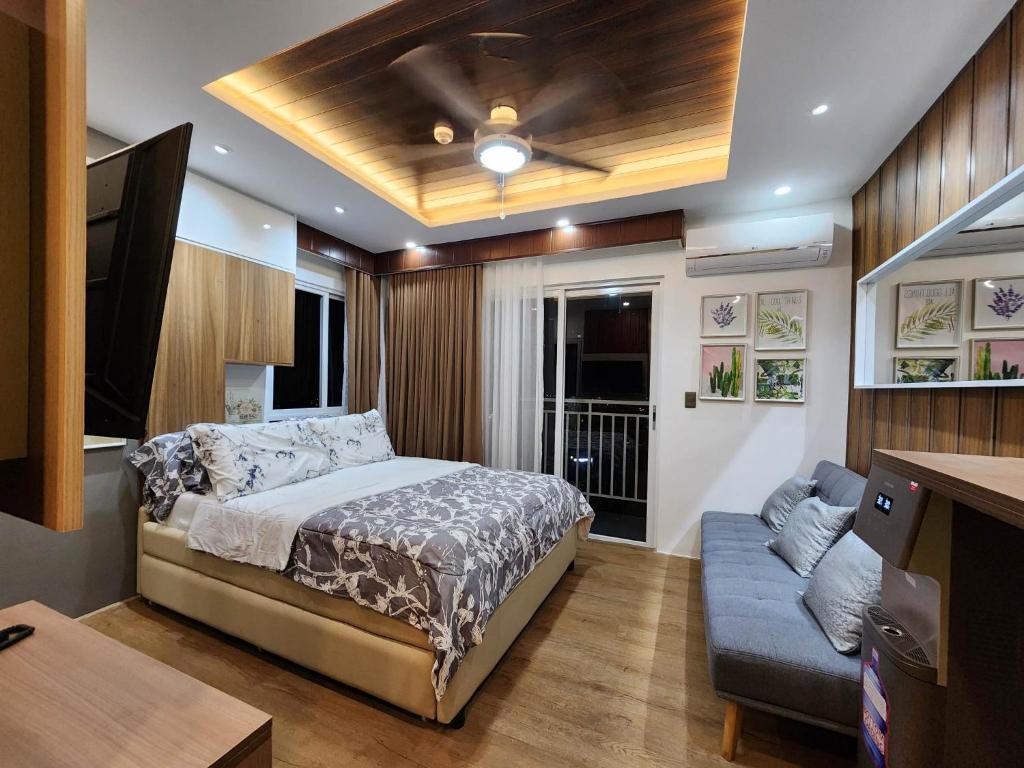 ダバオシティにある2124 Mesatierra Garden Residences with FREE WIFI and NETFLIXのベッドルーム(ベッド1台、ソファ付)