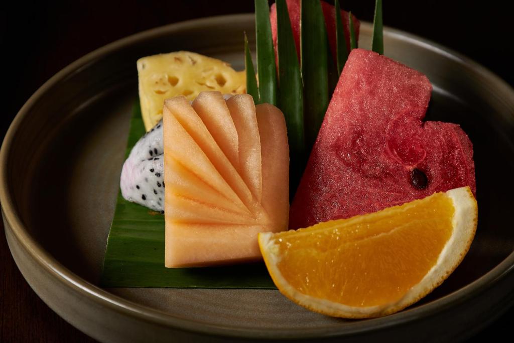 A neatly arranged plate of sliced tropical fruit.