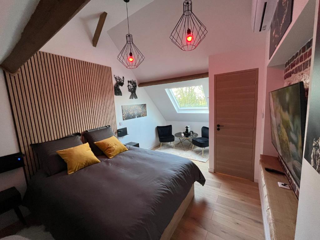 a bedroom with a large bed with pink walls at Appart' Zen & connect in Ennevelin