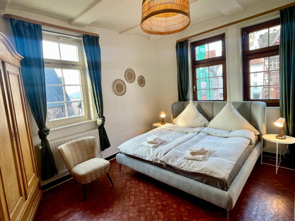 マールブルク・アン・デア・ラーンにあるVetters romantisches Gästezimmer in der Marburger Oberstadtのベッドルーム1室(ベッド1台、椅子、窓付)
