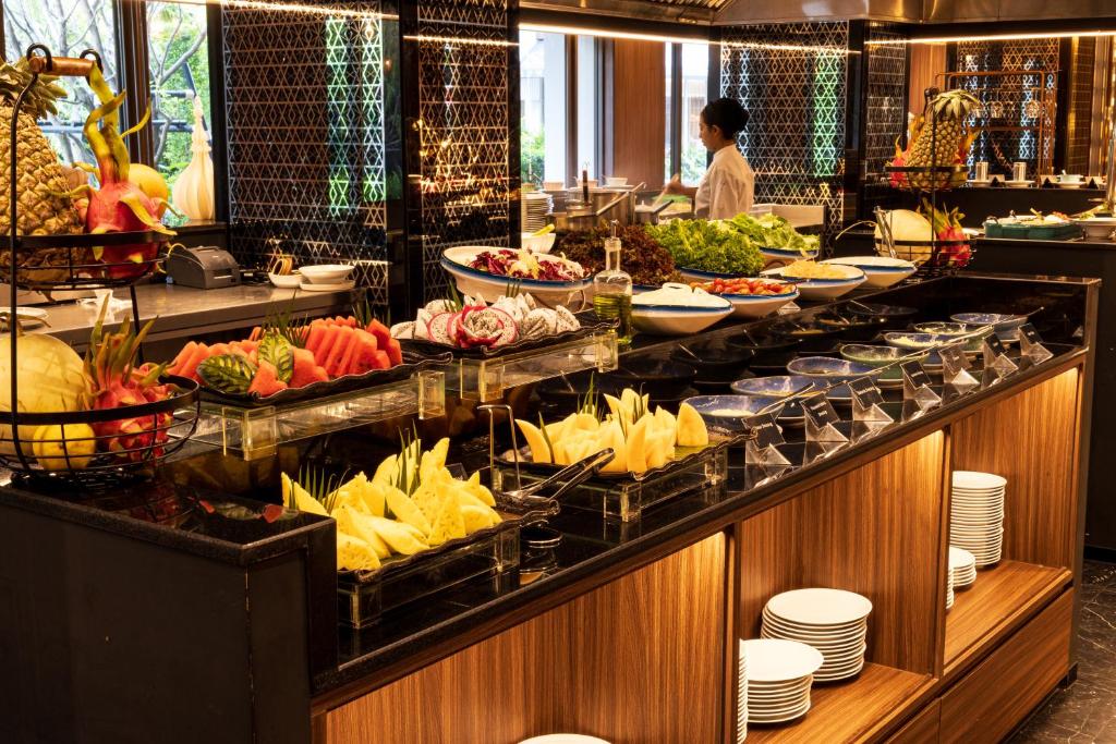 A staffed buffet counter offers fruit and prepared breakfast dishes.