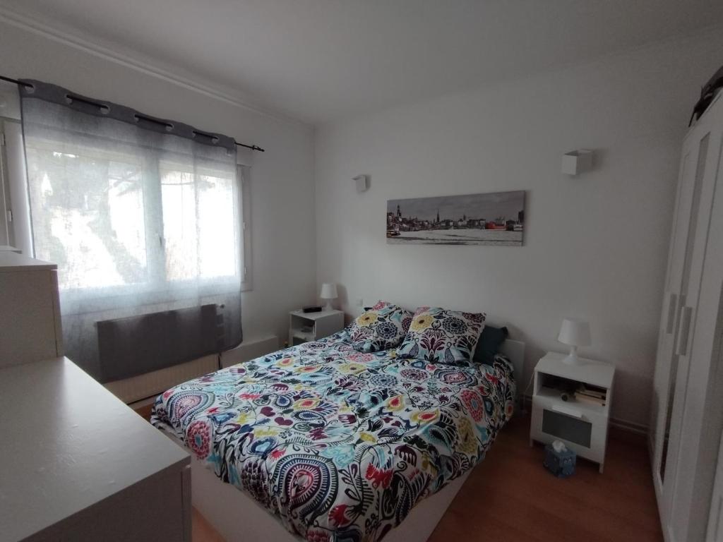 une chambre avec un lit avec une couette colorée dans l'établissement Simply fair by Disney, à Montry