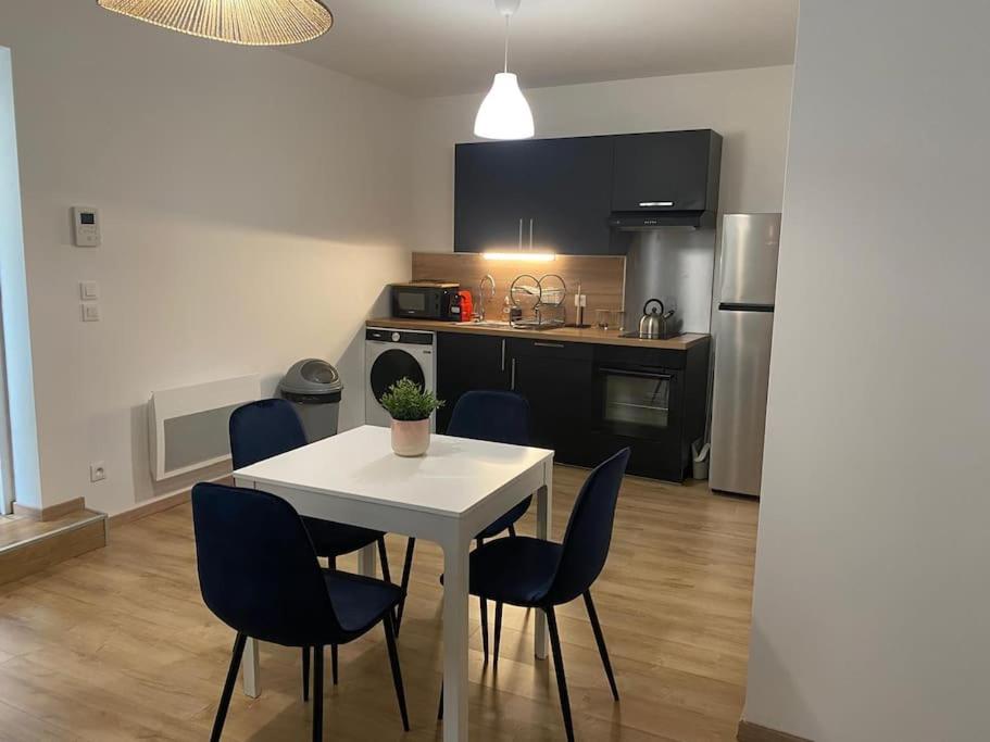 une cuisine avec une table blanche et des chaises bleues dans l'établissement Appartement cosy au cœur de Metz, à Metz
