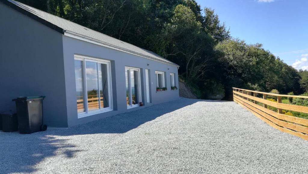 un bâtiment blanc avec des fenêtres et une clôture dans l'établissement Le grand large, à Bretteville