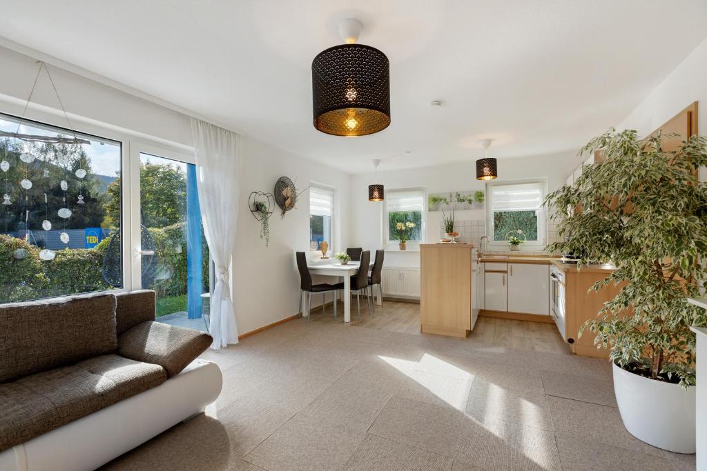 een woonkamer met een bank en een keuken bij Ferienwohnung Herzlicht in Titisee-Neustadt