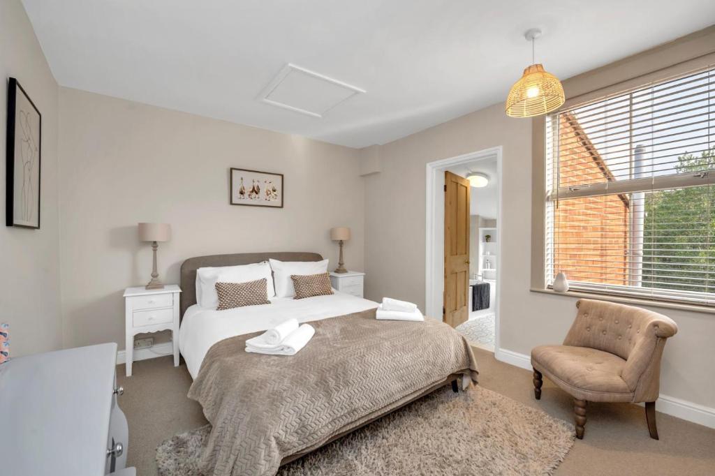 una camera da letto con un letto e una sedia di Delightful 10 St Martins - 2 bed, 2 bathroom with parking available a Bury Saint Edmunds