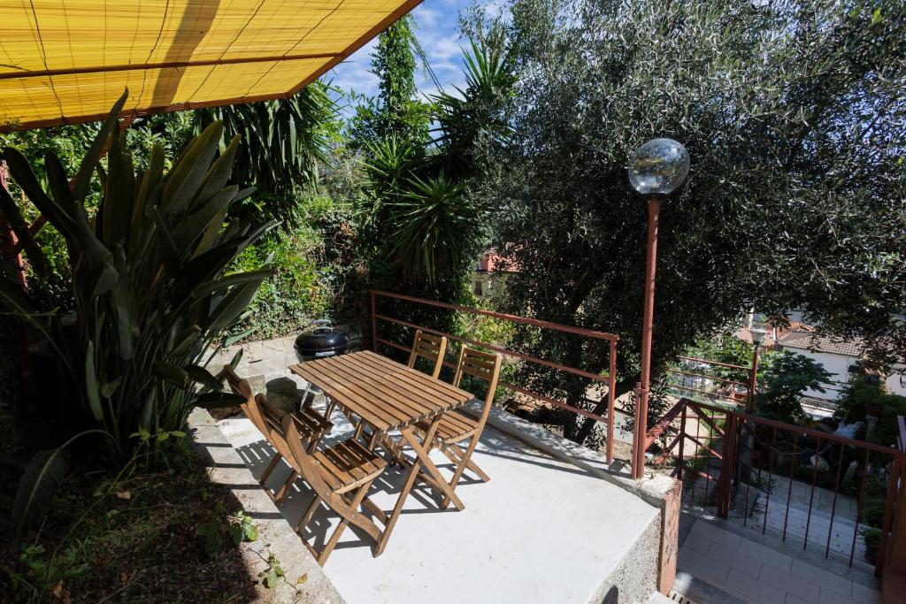 a patio with a table and chairs and a lamp at "Lomellina Bay" 10 minuti a piedi dal mare in Varazze