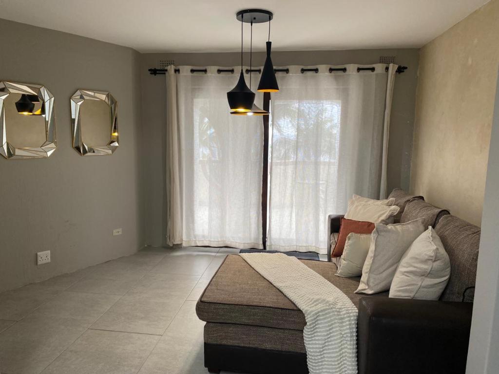 a living room with a couch and a window at Zinkwazi Beach House in Zinkwazi Beach